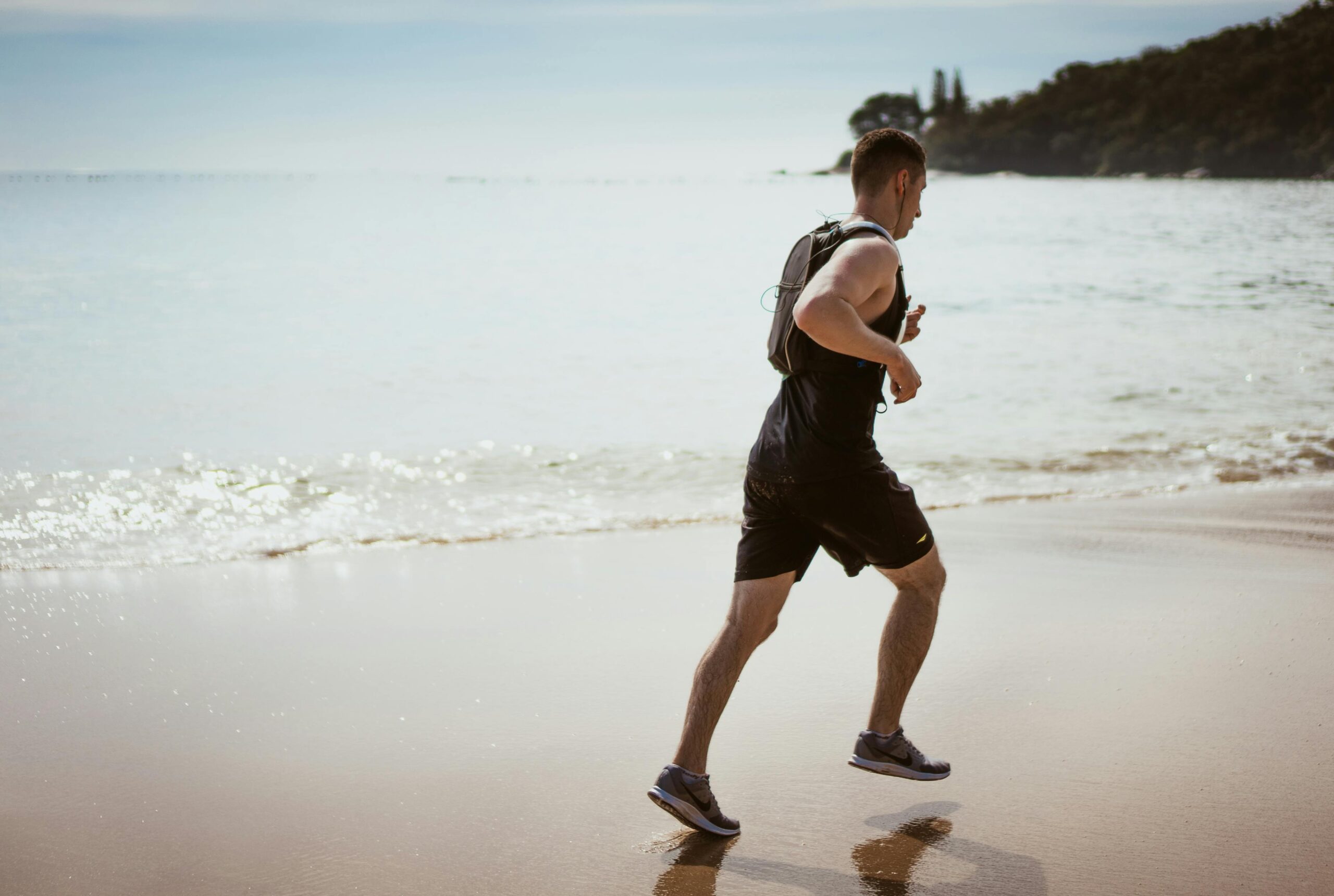 a picture of man jogging on a beach